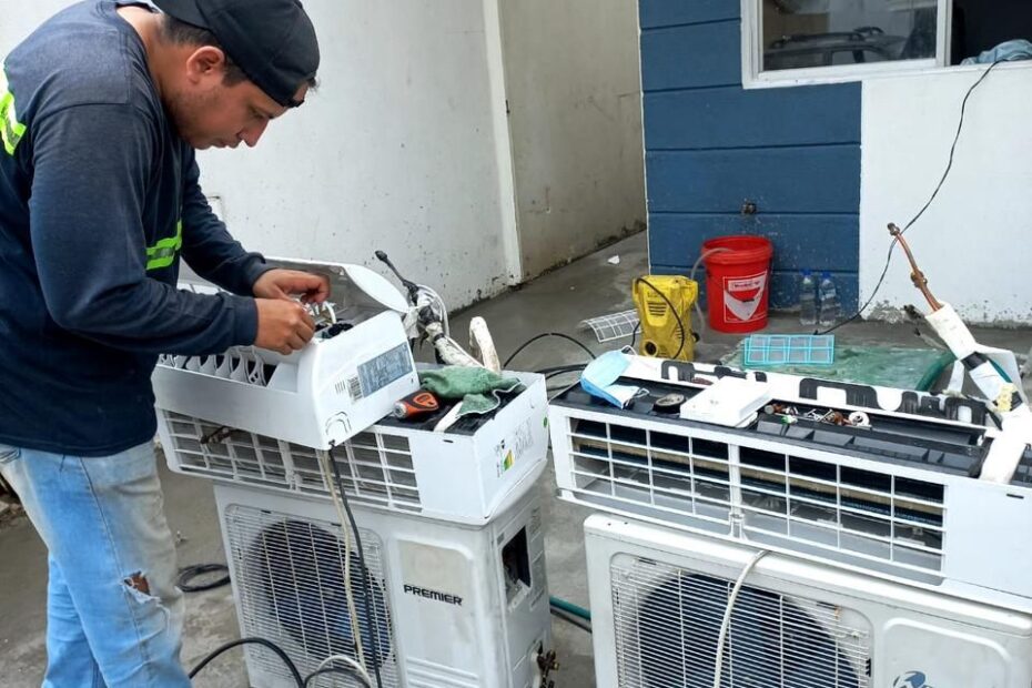 Tecnico reparando unidades de aire acondicionado en taller en Manta